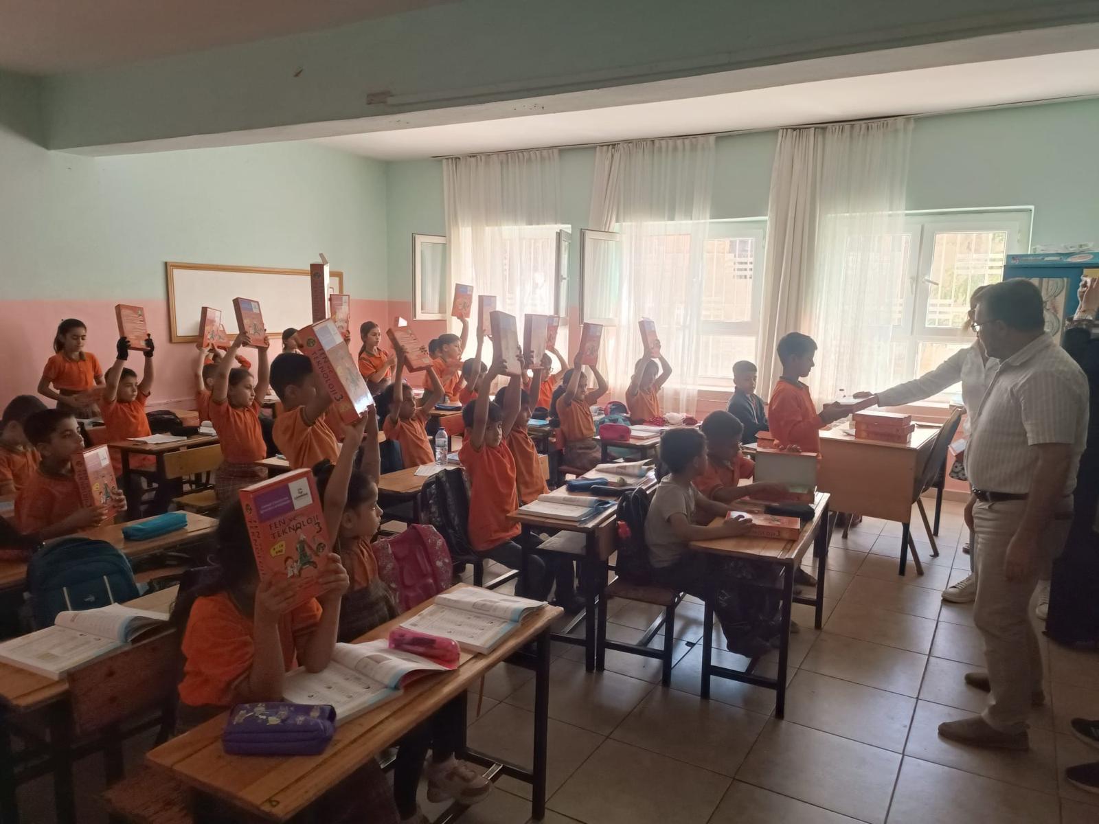 Birecikli öğrenciler hediye edilen deney setleriyle poz verirken